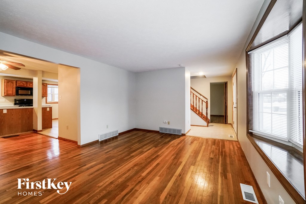 the living room and dining room with wood flooring and large windows
