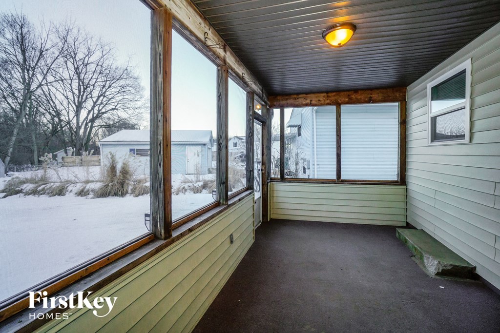 the screened in porch of a home in the snow