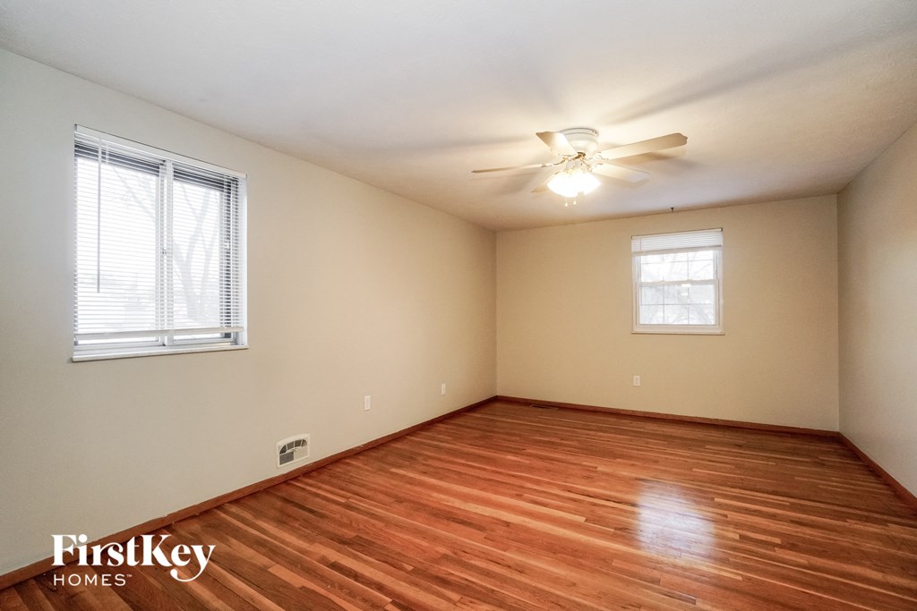a living room with wood floors and a ceiling fan