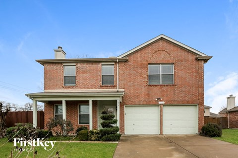 a brick house with two garage doors