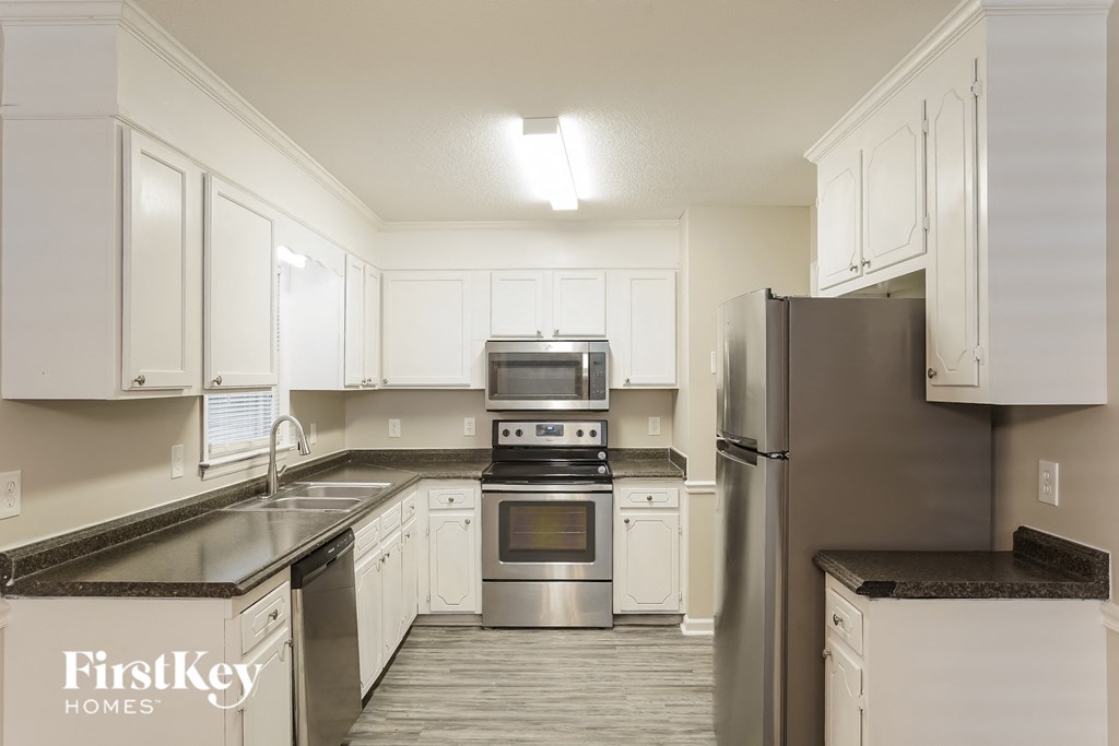 a kitchen with white cabinets and stainless steel appliances