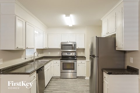 a kitchen with white cabinets and stainless steel appliances