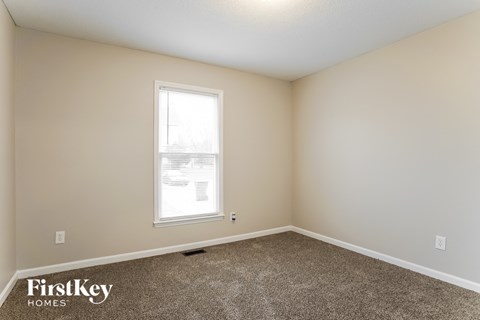 a bedroom with carpet and a window