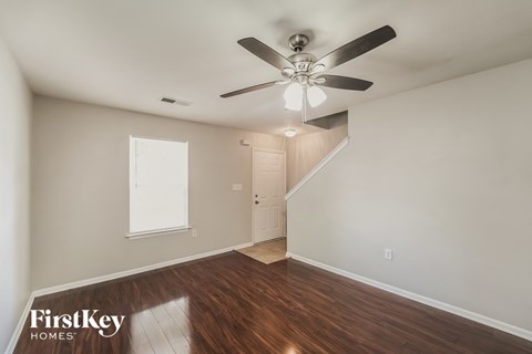 a living room with wood floors and a ceiling fan
