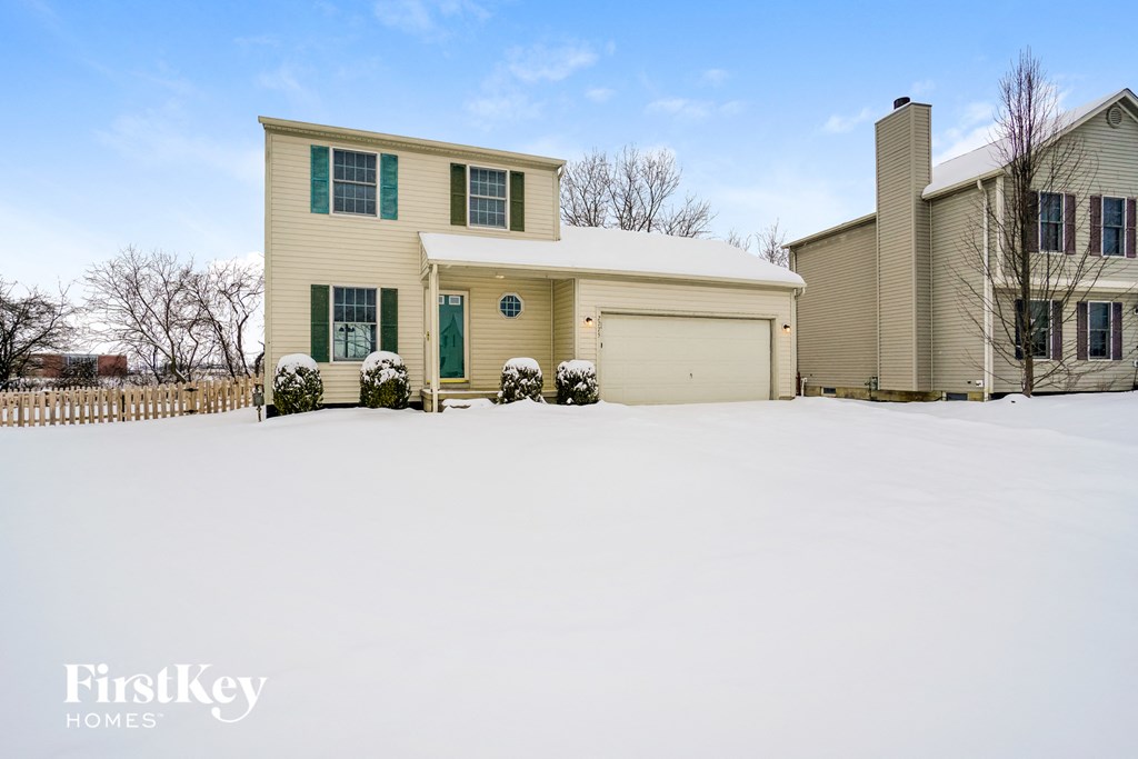 a house covered in snow with a white garage door