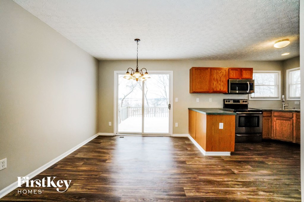 an empty kitchen and living room with a door to a balcony