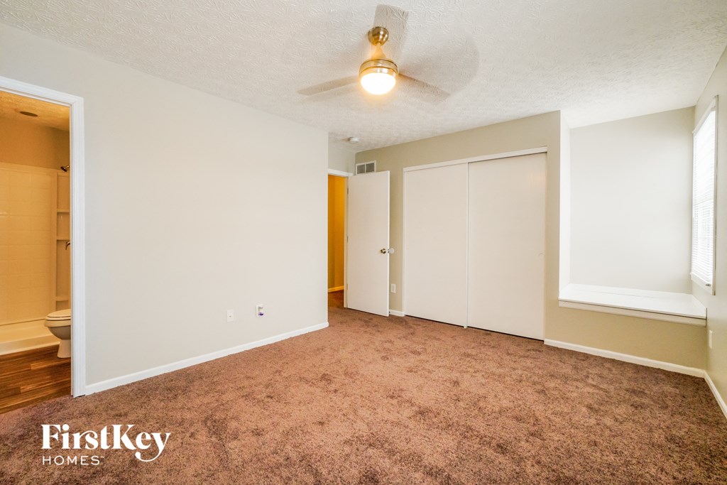 a living room with carpet and a ceiling fan