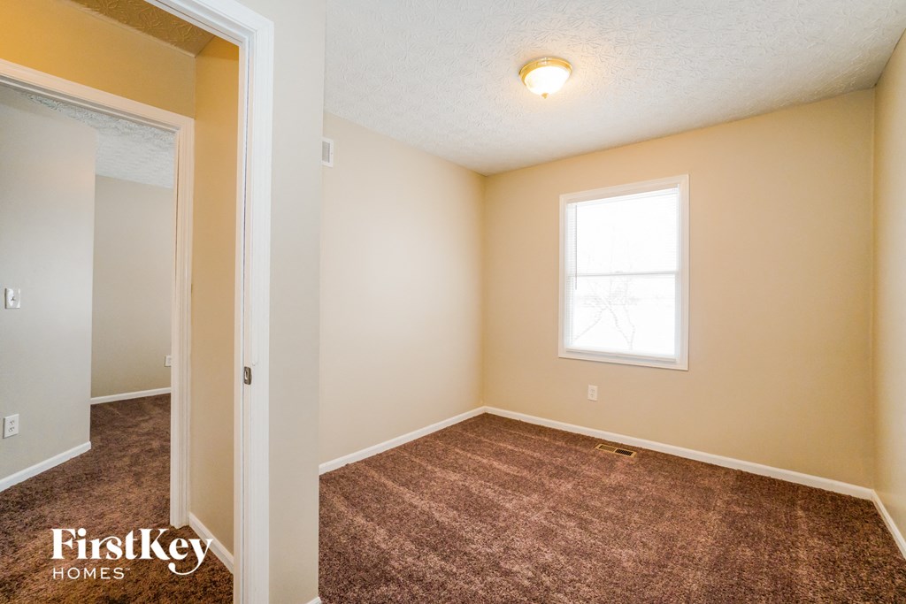a bedroom with a carpeted floor and a window