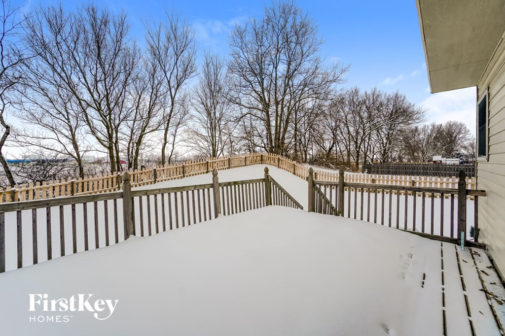 a deck with a fence covered in snow
