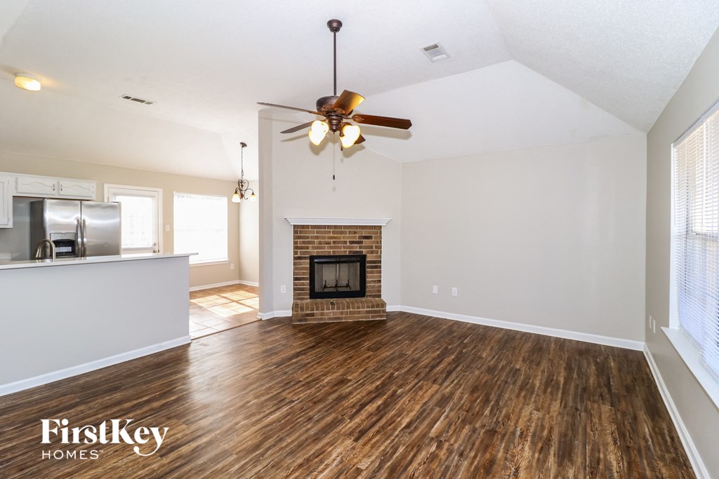 a living room with a fireplace and a ceiling fan