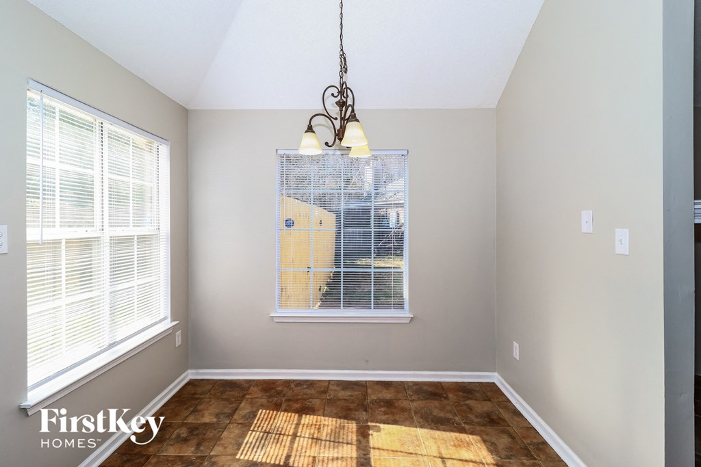 the living room of a home with a large window and a chandelier