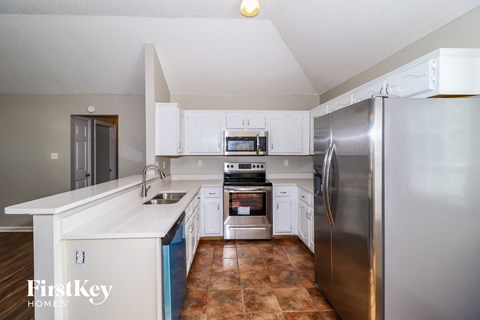 a kitchen with white cabinets and stainless steel appliances