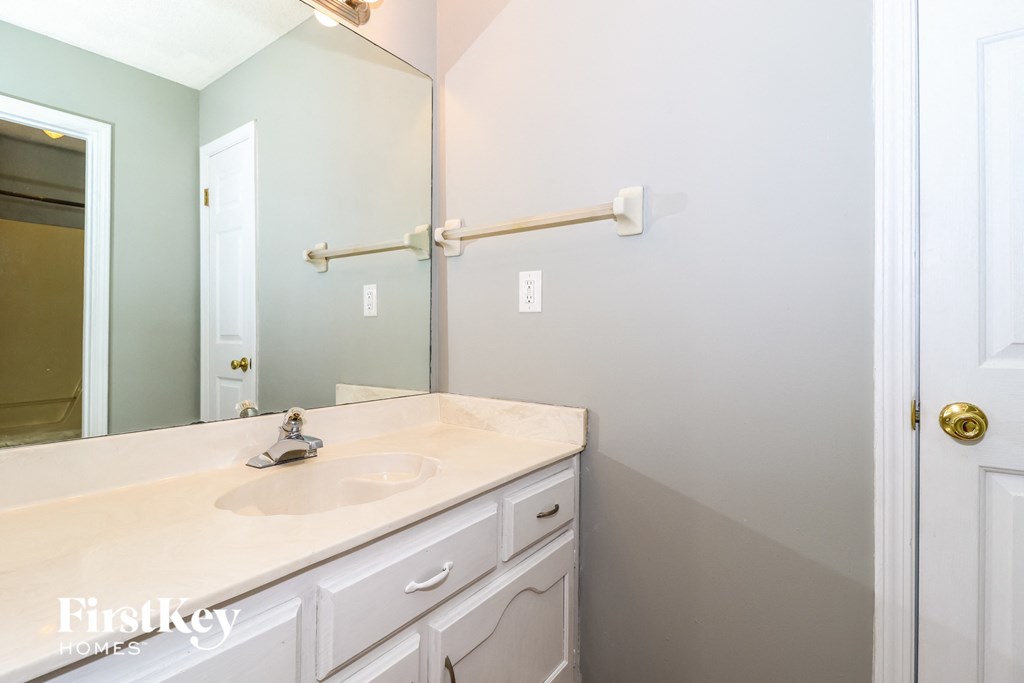a white bathroom with a sink and a mirror