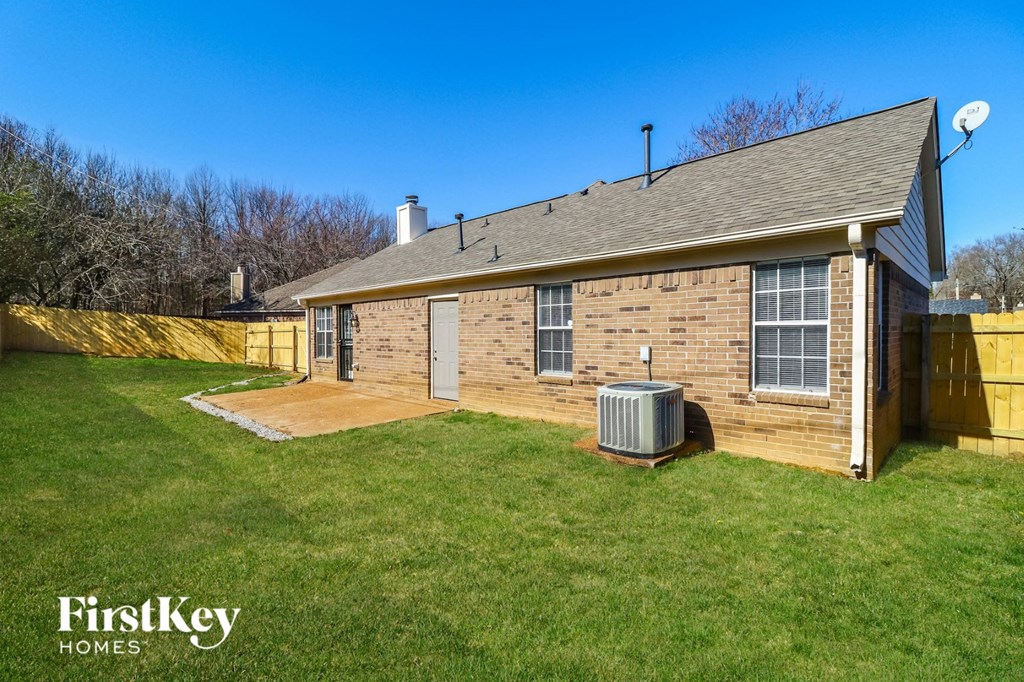 a small brick house with a yard and a backdoor