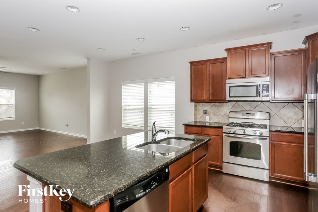 A kitchen with a granite countertop and stainless steel appliances.
