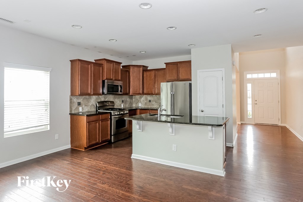 A kitchen with wooden cabinets and a white island.