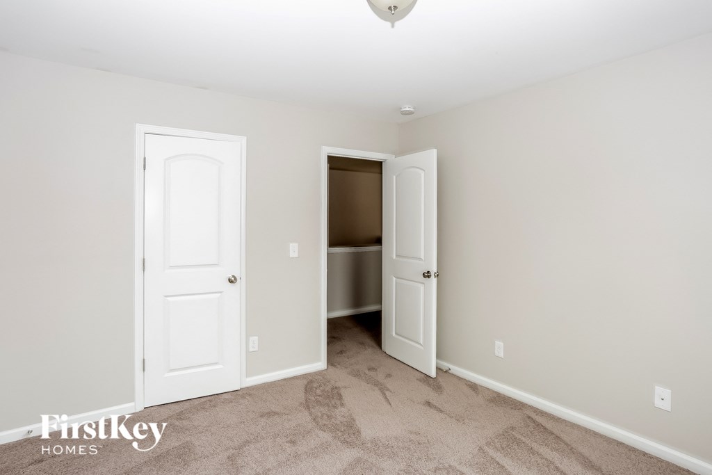 A room with two doors and a carpeted floor.