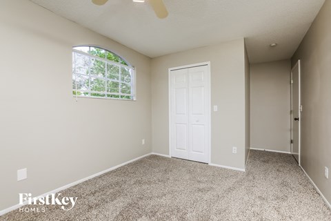 a bedroom with carpet and a white door and window