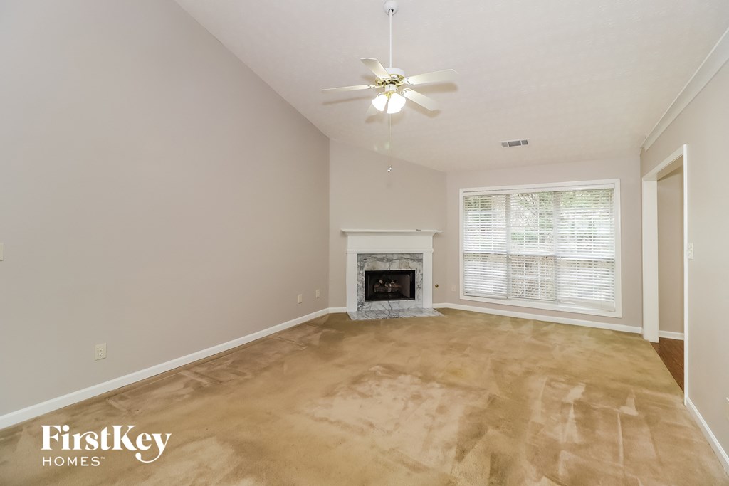 a living room with a fireplace and a ceiling fan