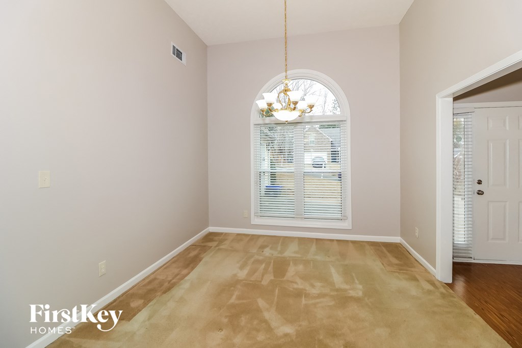 a living room with a large window and a chandelier
