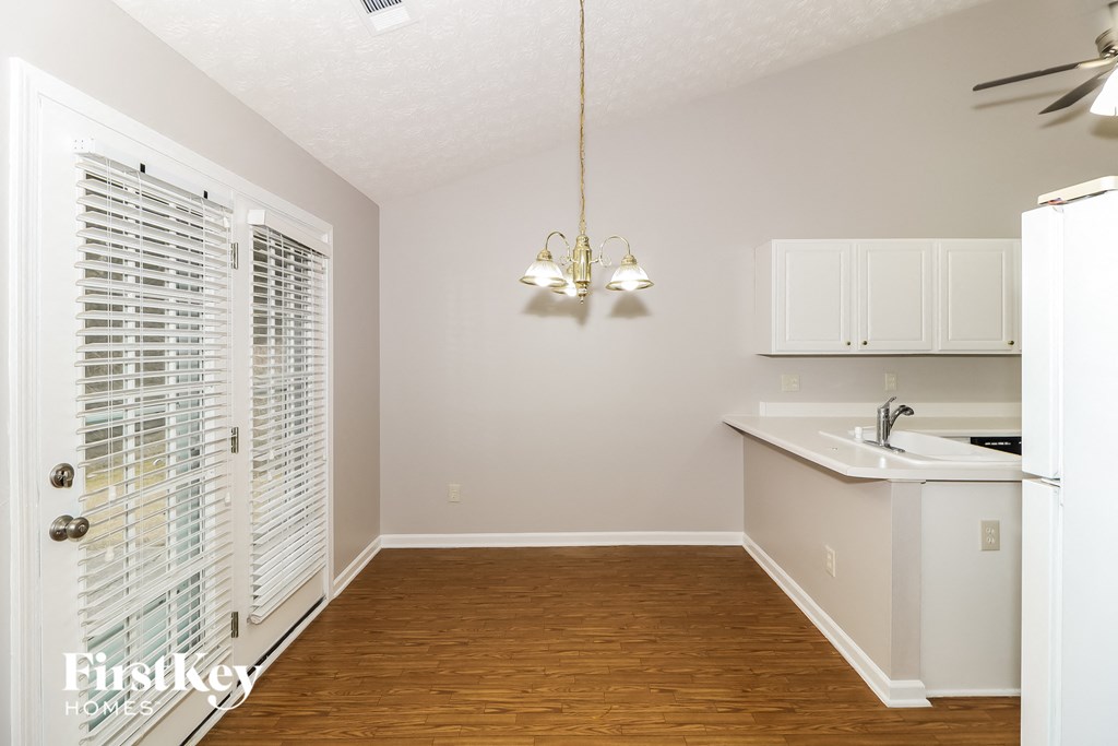 an empty kitchen with white cabinets and a white sink and a refrigerator