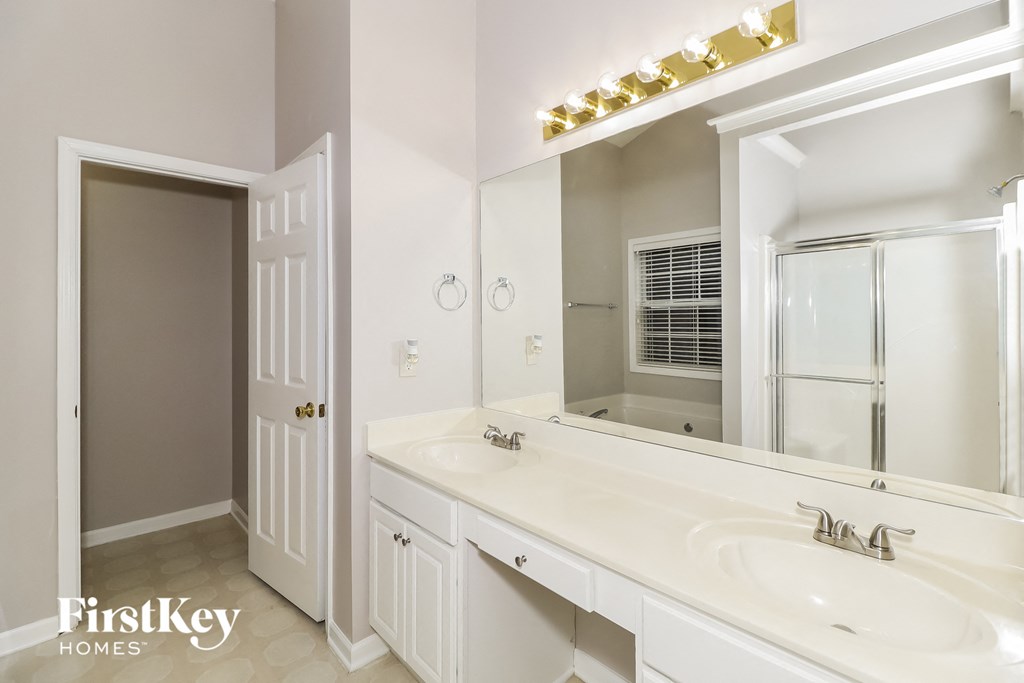 a bathroom with a sink and a mirror and a door to a closet
