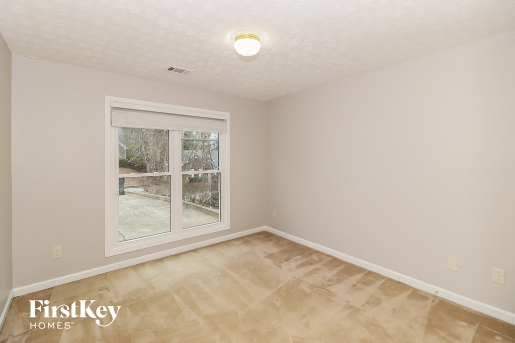 a bedroom with a large window and wooden floors