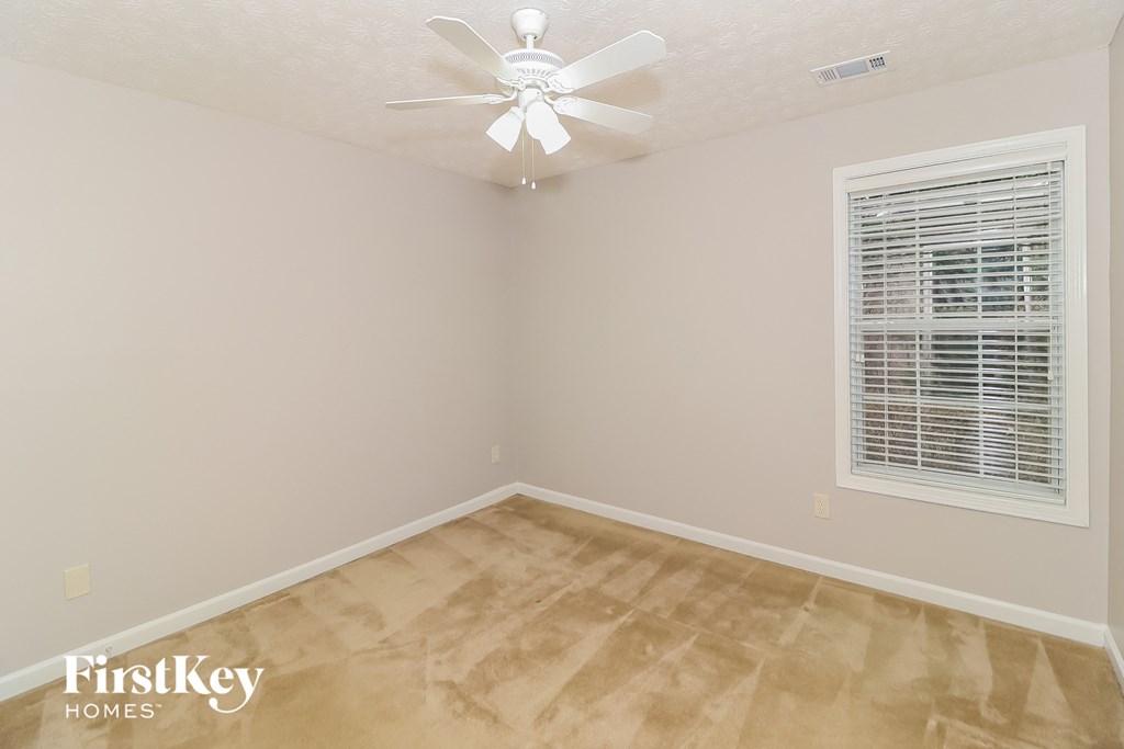 a bedroom with a ceiling fan and a window