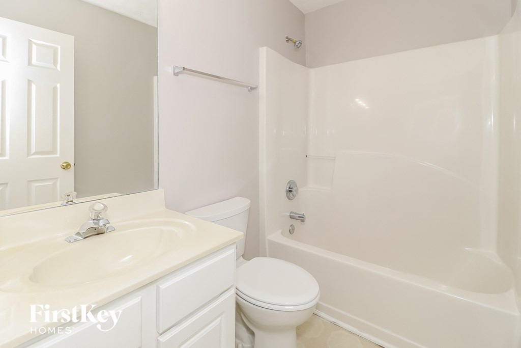 a white bathroom with a sink toilet and shower