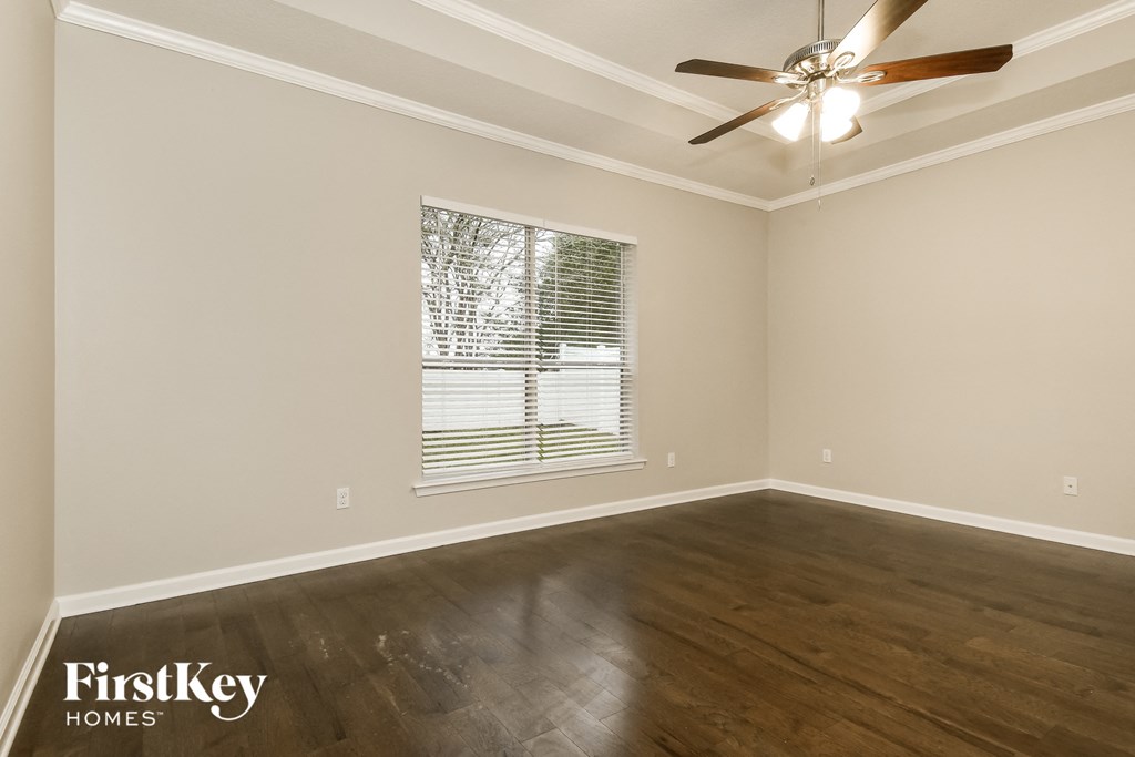 the living room of a home with wood floors and a ceiling fan