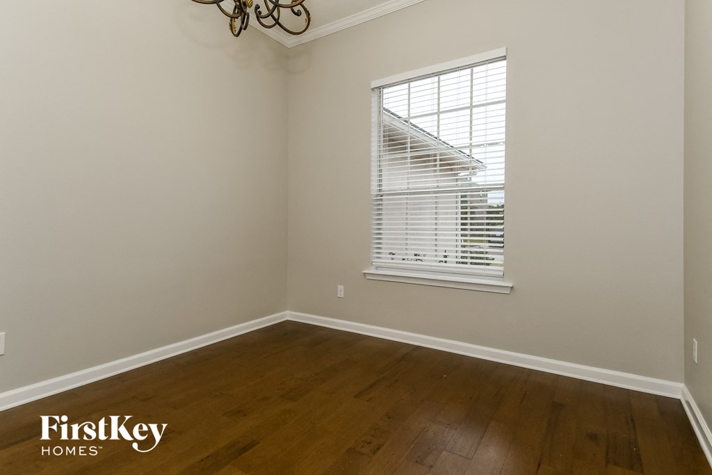 a bedroom with wood floors and a window