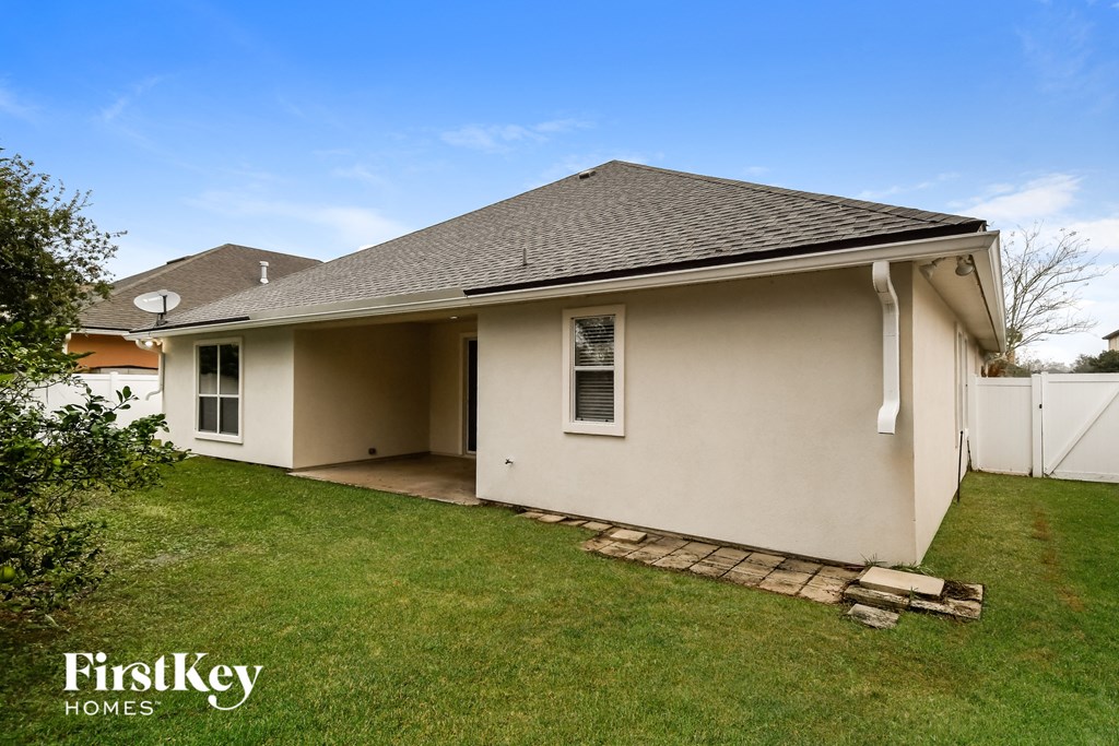 the backyard of a house with a lawn and a patio