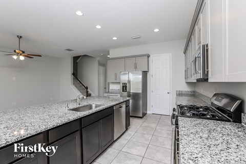 A kitchen with granite countertops and stainless steel appliances.