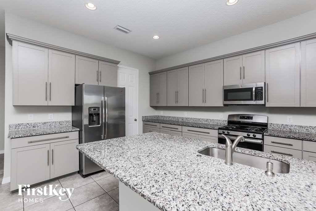 A kitchen with granite countertops and stainless steel appliances.
