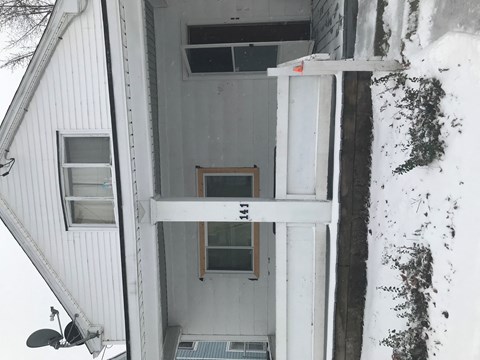 a view of the front door of a house in the snow