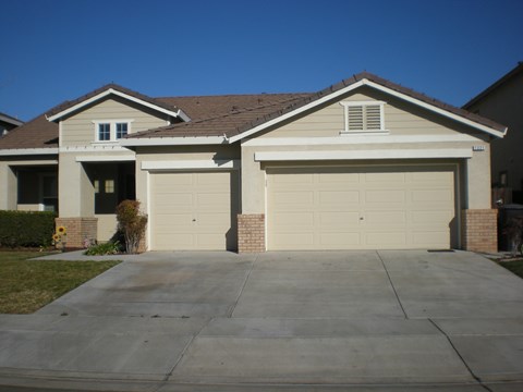A house with two garages and a driveway.