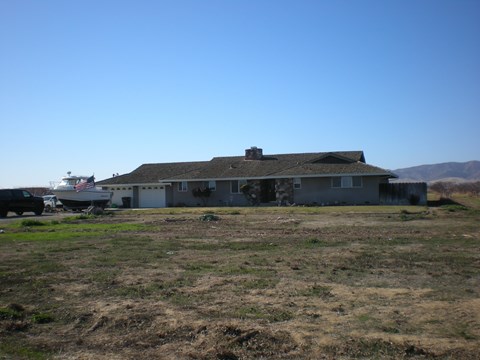 a house with a boat on the side of it in a field