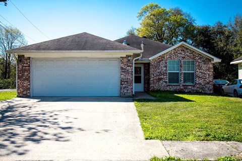 A house with a garage door and a driveway.