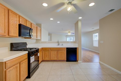 A kitchen with wooden cabinets and a black stove top oven.