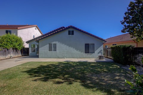 A house with a grey exterior and a red tile roof.