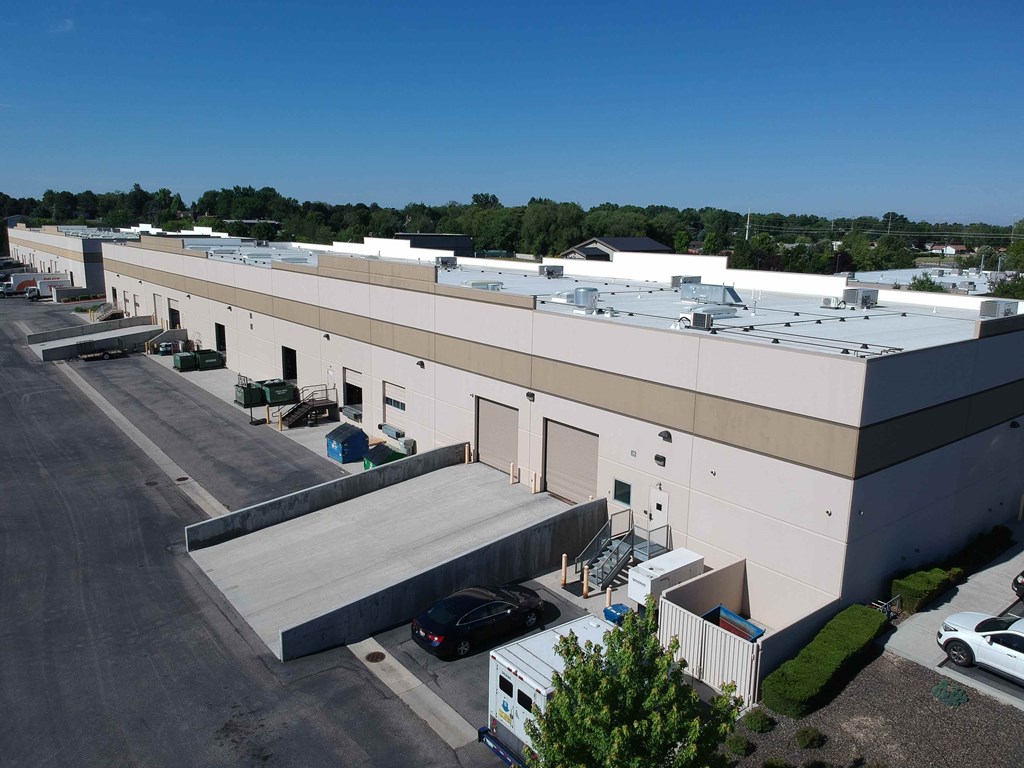 an aerial view of a white building with a parking lot