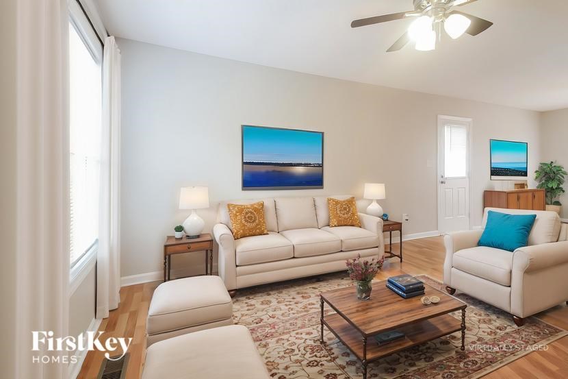 A living room with a white couch, a coffee table, and a painting on the wall.