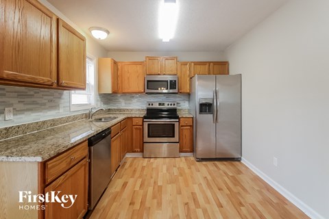 A kitchen with wooden cabinets and a stainless steel refrigerator.