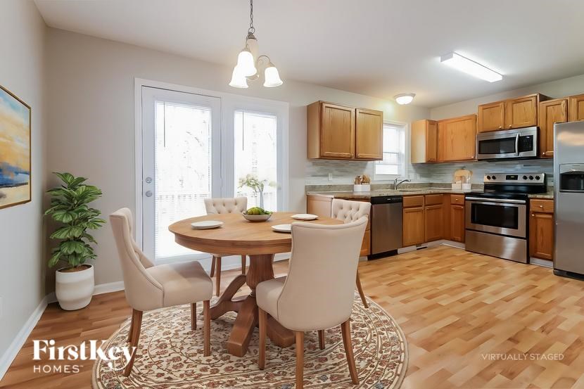 A kitchen with a dining table and chairs.