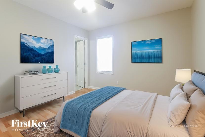 A bedroom with a bed, dresser, and two pictures on the wall.