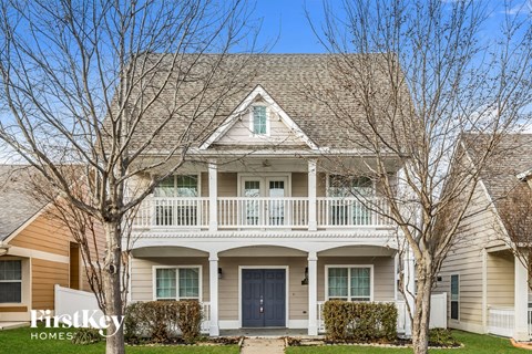 a white house with a porch and a blue door