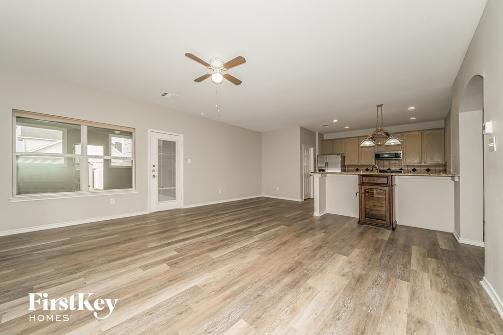 a kitchen and living room with wood flooring and a ceiling fan