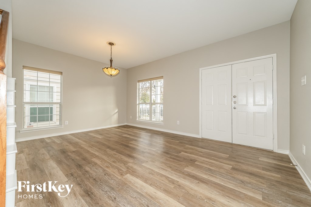 an empty living room with wood floors and a white door