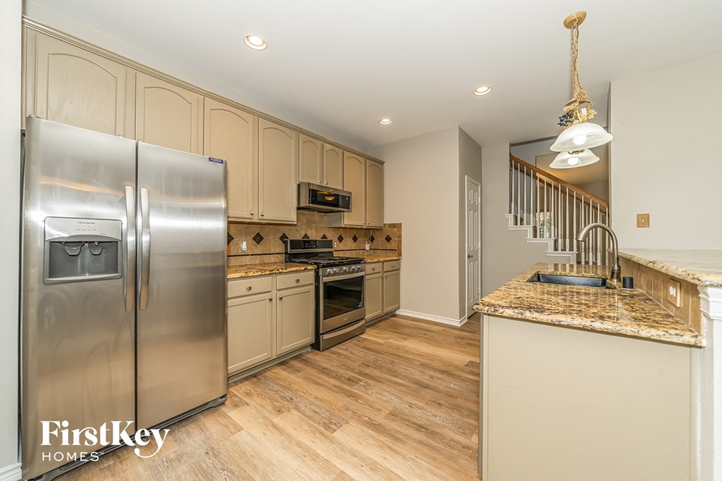 a kitchen with stainless steel appliances and a marble counter top