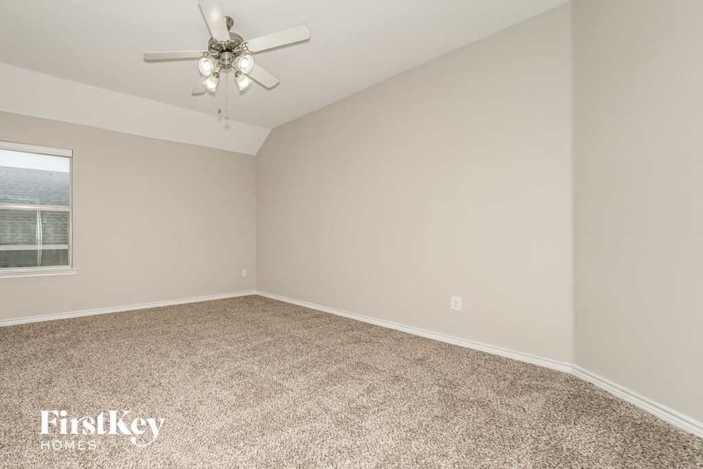 a bedroom with a carpeted floor and a ceiling fan